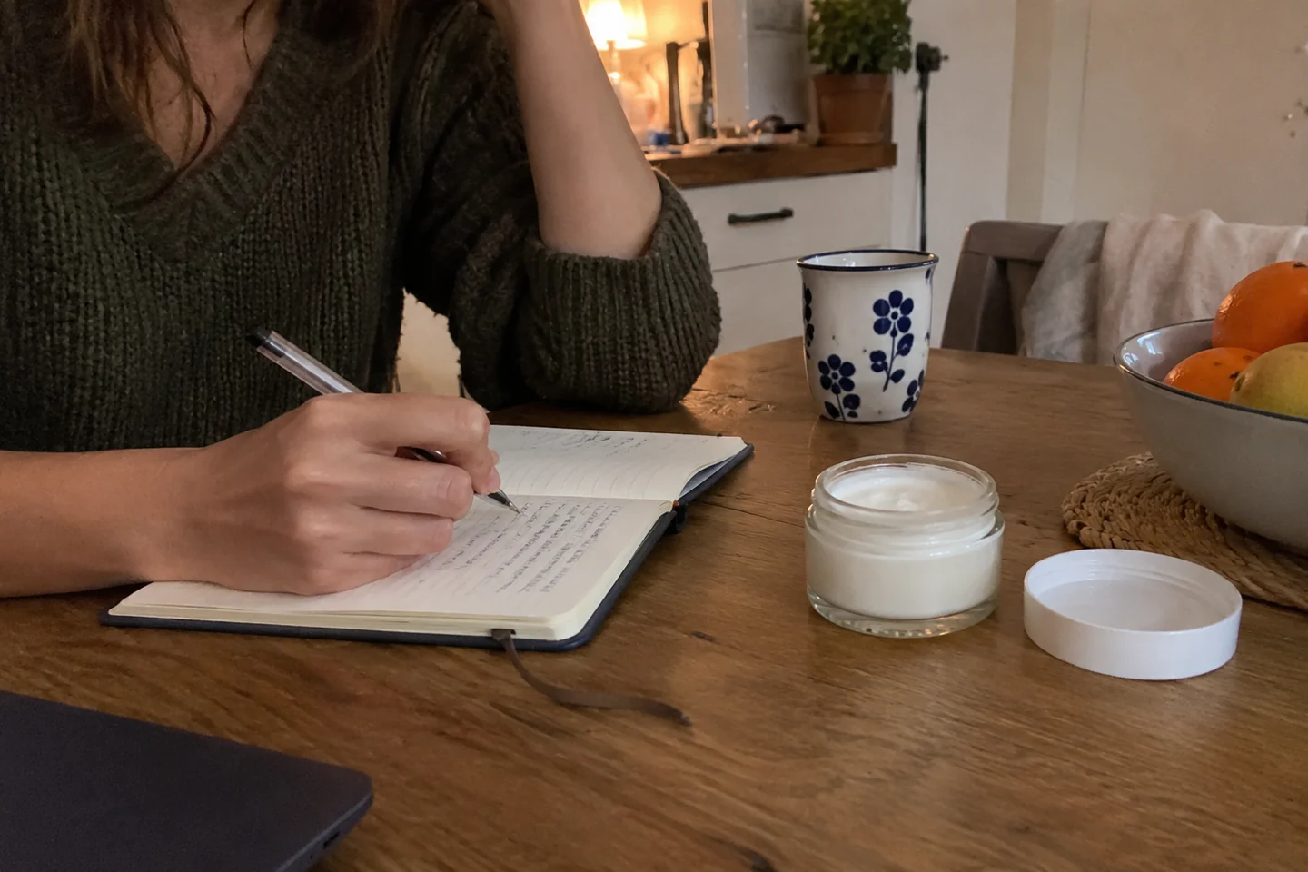 Un carnet et un soin neutre sur une table de cuisine
