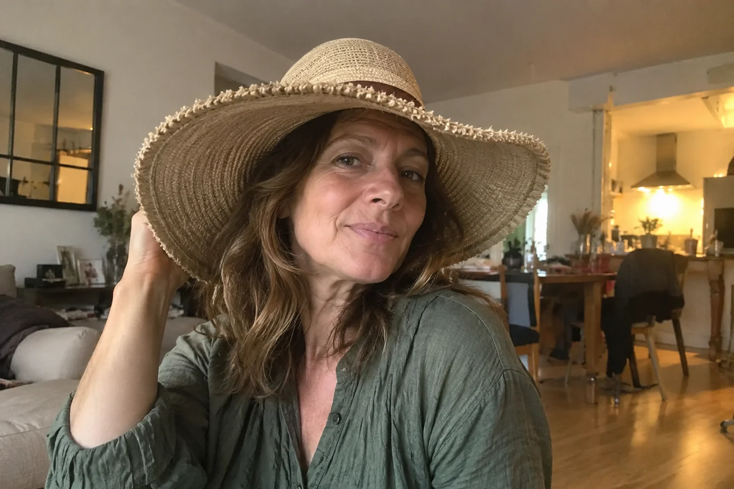 Une femme porte un chapeau à larges bords avant de sortir