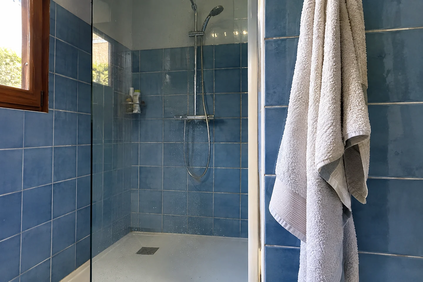 Une cabine de douche vide et une serviette propre à portée de main
