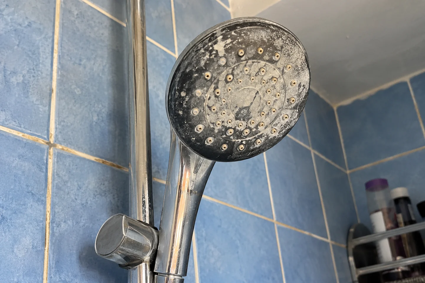 Une pomme de douche avec des traces blanches
