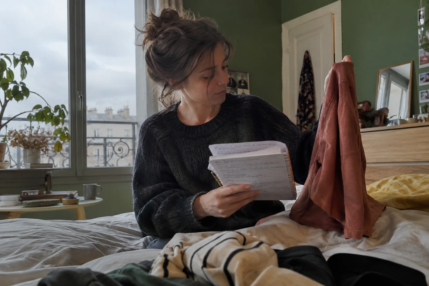 Une femme compare ses notes et un vêtement