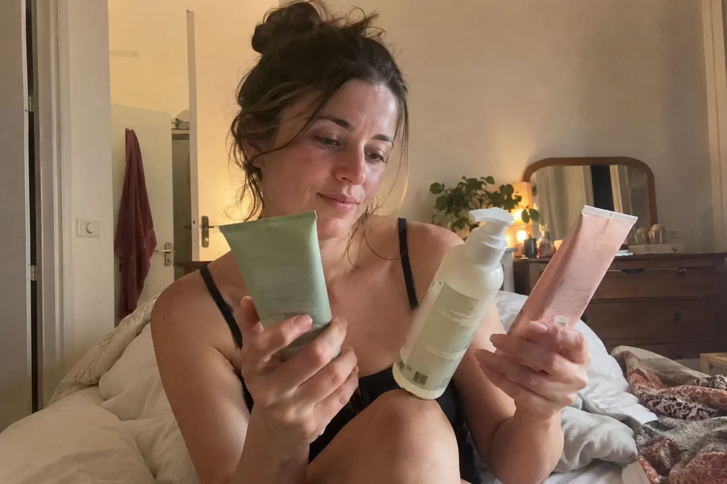 Une femme compare trois emballages de soins corporels