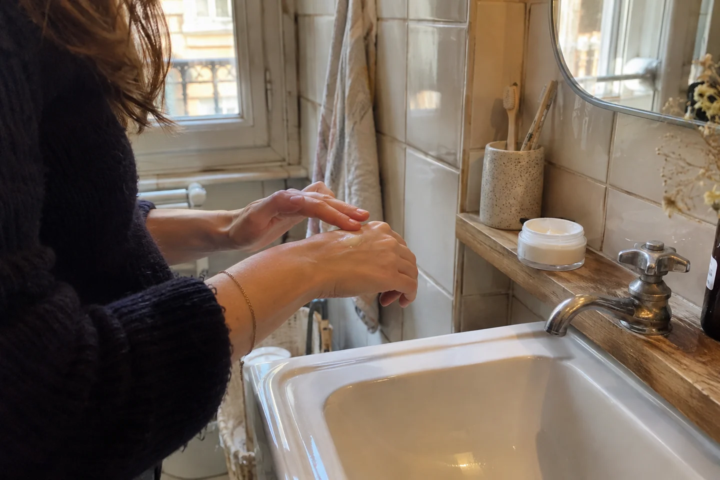 Une femme applique une petite quantité de crème sur sa main