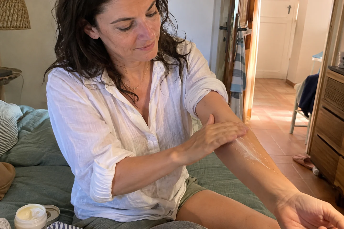 Une femme applique une crème sur son avant-bras avant le voyage