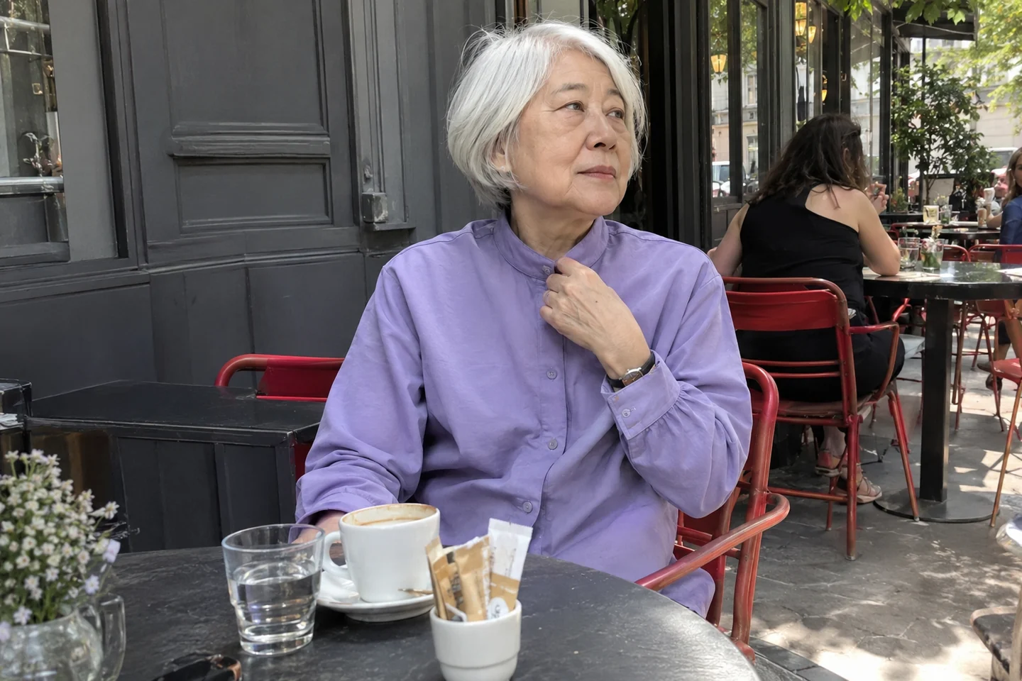 Une femme assise vérifie l’ouverture de son décolleté