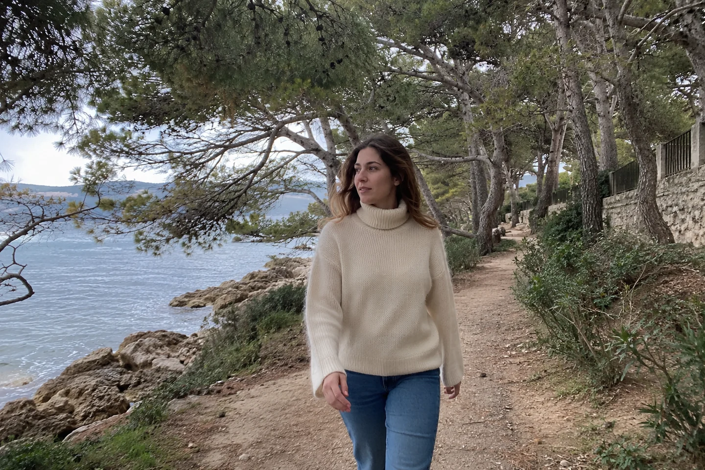 Une femme marche sous les arbres avec un col couvrant