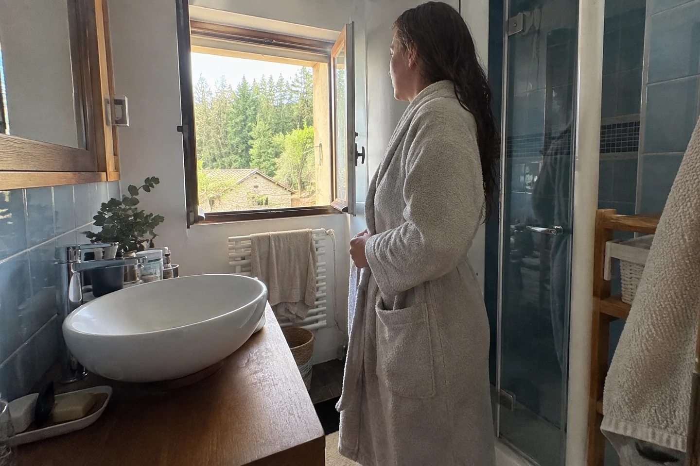 Une salle de bain avec fenêtre entrouverte après douche