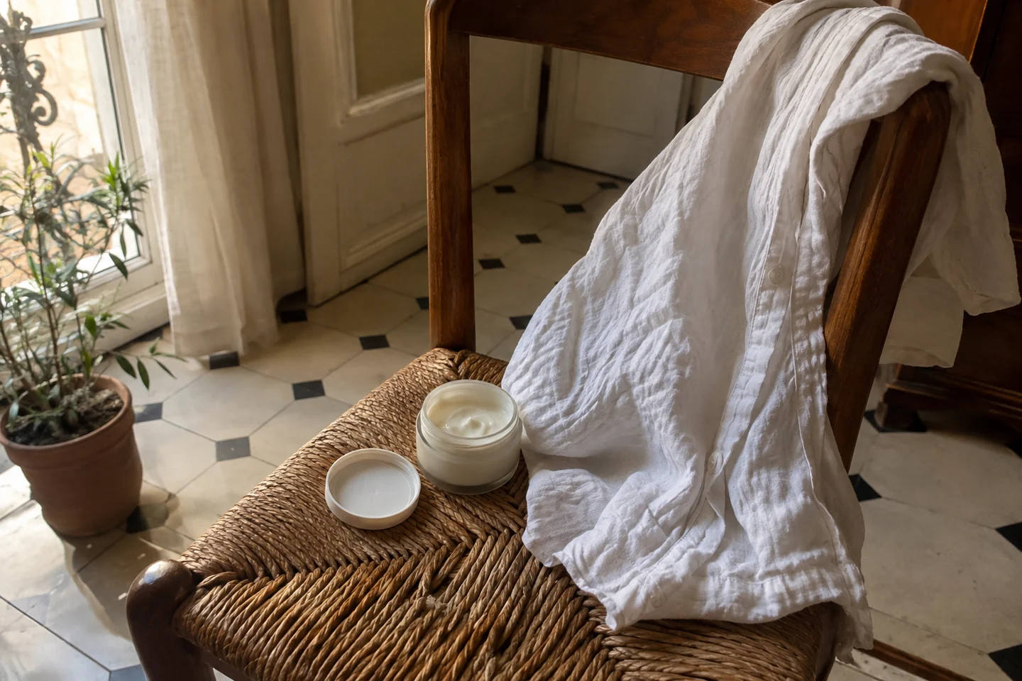 Une crème neutre et une chemise légère sur une chaise