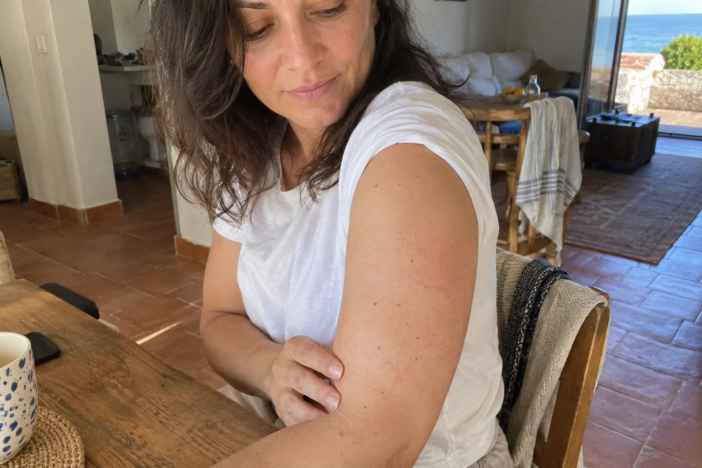 Une femme observe la peau de son bras